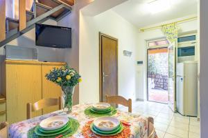 a dining room with a table and chairs and a tv at Simona Giardino in Fetovaia +17 photos