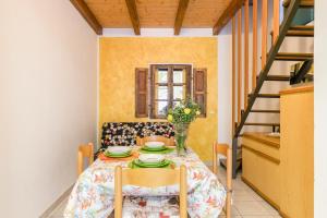 a dining room with a table and chairs and a staircase at Simona Giardino in Fetovaia