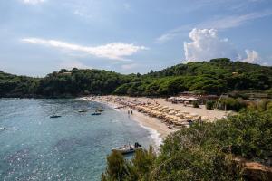a beach with umbrellas and a crowd of people at Simona Giardino in Fetovaia