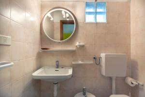 a bathroom with a sink and a mirror and a toilet at Simona Giardino in Fetovaia