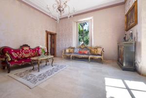 a living room with two couches and a chandelier at Historic Villa Argegno Como lake in Dizzasco