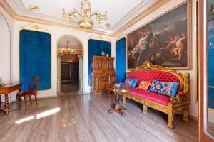 a living room with a red couch and a painting at Historic Villa Argegno Como lake in Dizzasco