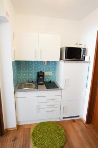 a small kitchen with a sink and a microwave at Zentral und Naturnah in Penzberg