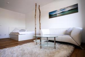 a living room with a white couch and a glass table at Zentral und Naturnah in Penzberg
