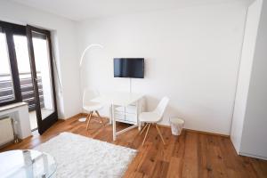 a white dining room with a table and chairs at Zentral und Naturnah in Penzberg