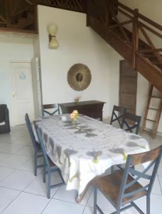 a dining room with a table with chairs and a mirror at Gite Terre Happy Ribérac in Ribérac +5 photos