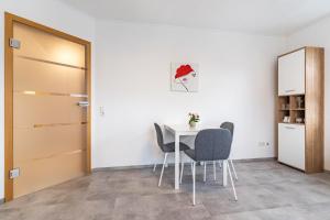 a dining room with a table and chairs and a door at Fewo Gartenblick in Oberharmersbach