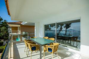 a glass table and chairs on the balcony of a house at Catalina 3b in Port de Pollensa