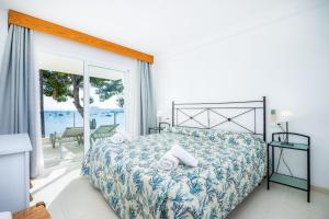 a bedroom with a bed and a view of the ocean at Catalina 3b in Port de Pollensa
