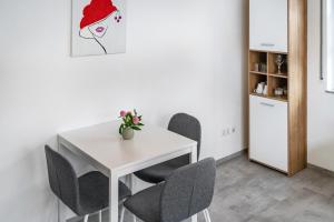 a white table with chairs and a vase of flowers on it at Fewo Gartenblick in Oberharmersbach