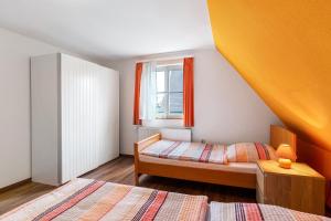 a small bedroom with two beds and a window at Lebensblume in Ilshofen