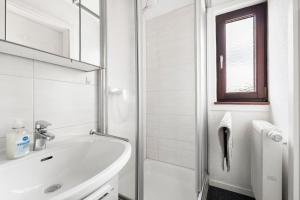 a white bathroom with a sink and a shower at Lebensblume in Ilshofen +24 photos