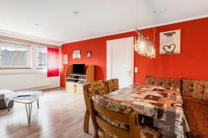 a dining room with red walls and a table and chairs at Lebensblume in Ilshofen