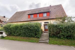 a house with a red door and some bushes at Lebensblume in Ilshofen