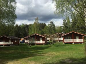 un groupe de cottages dans un champ arboré dans l'établissement Steinvik Camping, à Moelv