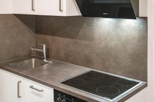 a kitchen with a sink and a stove at Fewo Gartenblick in Oberharmersbach +12 photos