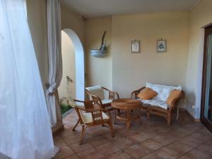 a living room with a couch and a table and chairs at Il Giardino di Viola in Porto Ottiolu