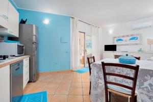 a kitchen and a dining room with a table in a room at Il Giardino di Viola in Porto Ottiolu