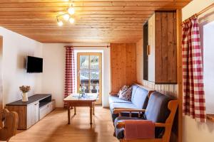 a living room with a blue couch and a table at Haus Niklos - Waldeck in Grainau