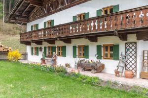 a woman standing outside of a house with flowers at Haus Niklos - Waldeck in Grainau