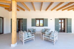 a patio with chairs and a table and windows at Villa Lorena in Islas Baleares