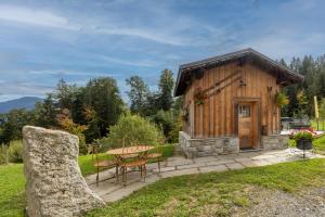 a small wooden cabin with a table and chairs at Petit Chalet Cosy in Combloux