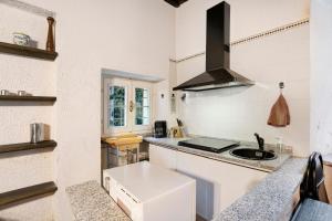 a white kitchen with a sink and a stove at in Villa Belli in Miasino +10 photos