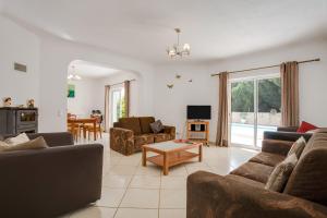 a living room with couches and a table at Casa das Romanzeiras in Carvoeiro