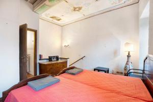 a bedroom with a bed with an orange blanket at in Villa Belli in Miasino
