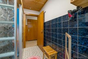 a bathroom with blue tiles on the wall and a door at Ferienhaus Störzel - Wohnung A in Hundheim