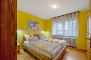 a bedroom with yellow walls and a large bed at Ferienhaus Störzel - Wohnung A in Hundheim