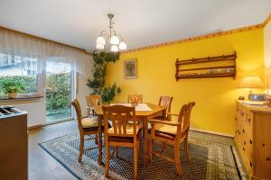 a dining room with a wooden table and chairs at Ferienhaus Störzel - Wohnung A in Hundheim +19 photos