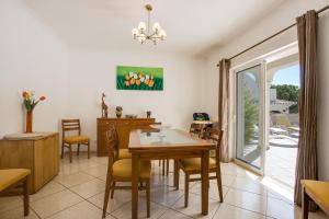 a dining room with a table and chairs and a sliding glass door at Casa das Romanzeiras in Carvoeiro