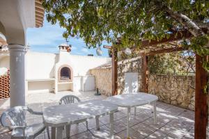 a patio with a table and chairs and a building at Casa das Romanzeiras in Carvoeiro