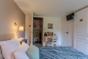 a bedroom with a bed and a desk and a table at Maison Loustalet in Arzacq-Arraziguet