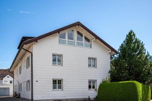 a white house with a brown roof at Paulas Ferienwohnung Koenigscard in Füssen