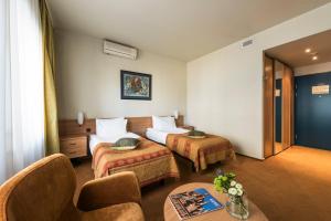 a hotel room with two beds and a table at BEST BALTIC Kaunas in Kaunas +44 photos