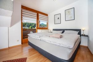 a large bed in a room with a window at Paulas Ferienwohnung Koenigscard in Füssen