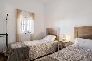 a hotel room with two beds and a window at Los Olivos in Barbate +16 photos