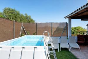 a swimming pool with chairs and a swimming pool at Los Olivos in Barbate