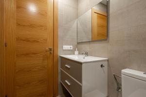 a bathroom with a sink and a mirror and a toilet at 4 Jardin- Puerto Chico in Llanes +19 photos