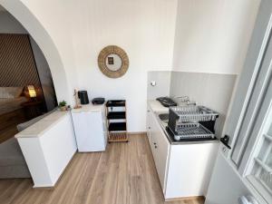 a small kitchen with white cabinets and a stove at aeolian blu 1 in Parikia