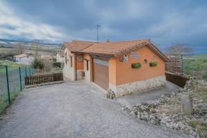 a small orange house with a garage at La Cardeñuela in Burgos