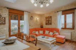 a living room with an orange couch and a table at La Cardeñuela in Burgos