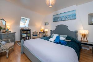 a bedroom with a large bed and a chair at Ty Al Louarn - Piscine - Spa in Brech +19 photos