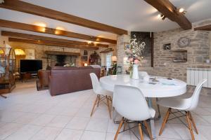 a dining room with a white table and chairs at Ty Al Louarn - Piscine - Spa in Brech