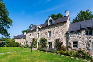 an old stone house with a yard at Ty Al Louarn - Piscine - Spa in Brech