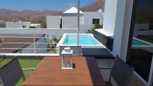a balcony with a table and a swimming pool at Amanecer 4 in Mácher