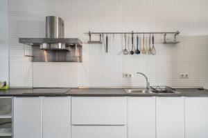 a kitchen with white cabinets and a sink at Amanecer 4 in Mácher