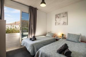 two beds in a room with a window at Amanecer 4 in Mácher
